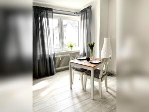 d'une salle à manger avec une table, des chaises et une fenêtre. dans l'établissement Ferienwohnung Apothekerhaus, à Bad Sassendorf