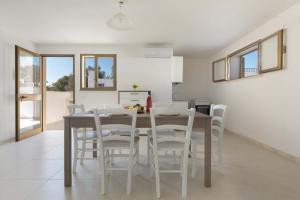 - une cuisine et une salle à manger avec une table et des chaises dans l'établissement Casetta di Silvia by BarbarHouse, à Marina di Pescoluse