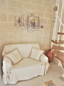 a living room with a white couch and a staircase at Casa Sant'Agata in Laterza +17 photos