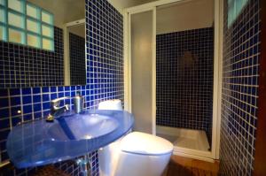 a blue tiled bathroom with a toilet and a sink at CASA TERESA in Albanya +74 photos