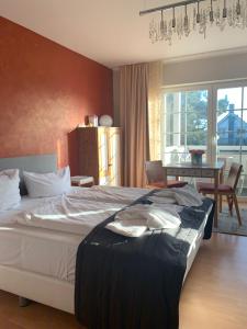 a bedroom with a large bed and a dining room at ART-hüs in Westerland (Sylt)