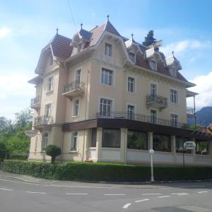 a large white building on the side of a street at Hotel De La Paix in Interlaken