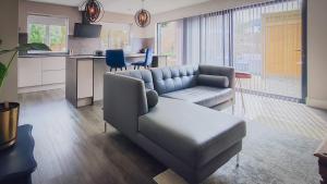 a living room with a couch and a kitchen at The Angel Holiday House in Warminster