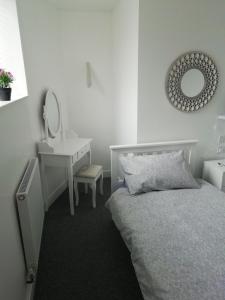 a bedroom with a bed and a sink and a mirror at The Antelope Hotel in Merthyr Tydfil