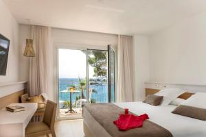 a hotel room with a bed and a view of the ocean at Hotel Costa Brava in Platja  d'Aro