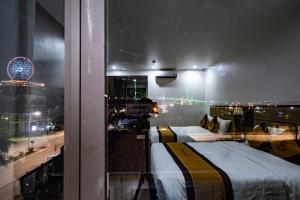 Un dormitorio con dos camas y vistas a una ciudad. en LUXURY II HOTEL, en Ha Long
