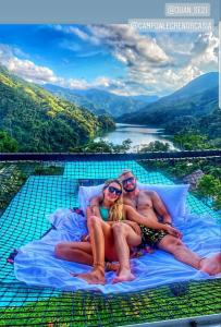 a man and a woman sitting on a bed with a view at Ecohotel Campo Alegre Norcasia Caldas in Norcasia