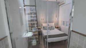 マドリードにあるApartamento Malasaña IIのベッド1台とシンク付きの小さな客室です。