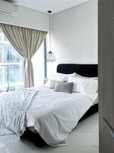 un letto bianco in una camera da letto con finestra di Signature Apartment at Summer Suites klcc a Kuala Lumpur