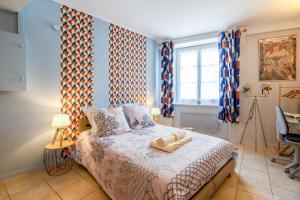 een slaapkamer met een bed in een kamer met blauwe muren bij SUPERLOGIS Bel Epoque STUDIO BLOIS-HYPERCENTRE in Blois