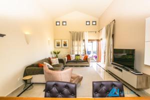 ein Wohnzimmer mit einem Sofa und einem TV in der Unterkunft Casa Braeside - LH204 By Villas Now Ltd in Playa Blanca