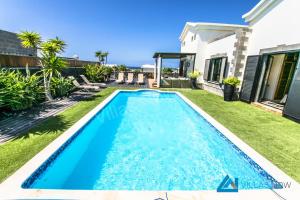 a swimming pool in the backyard of a house at Casa Braeside - LH204 By Villas Now Ltd in Playa Blanca