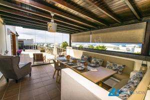 a dining room with a view of the ocean at Casa Braeside - LH204 By Villas Now Ltd in Playa Blanca
