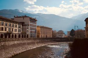 a river in a city with buildings and mountains at Hotel Europa in Sondrio