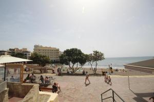 a group of people on a beach with the ocean at Apartment El Medano Sunset in El Médano