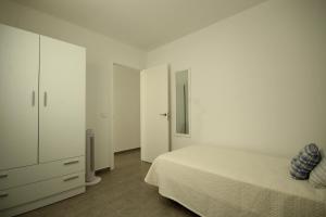 a white bedroom with a bed and a dresser at Apartment El Medano Sunset in El Médano