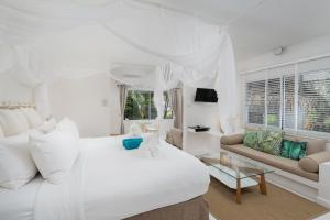 a white bedroom with a white bed and a couch at King's Garden Resort - SHA Plus in Chaweng