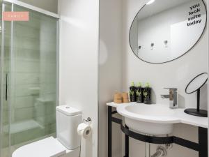 a bathroom with a toilet and a sink and a mirror at Limehome Sevilla Calle Torcuato Luca de Tena - Digital Access in Seville