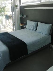 1 cama en un dormitorio con ventana grande en Knysna Budget Friendly Stay, en Knysna