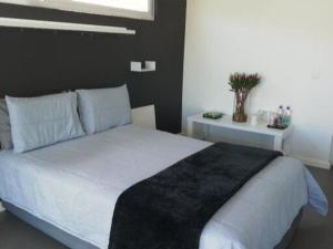 sypialnia z dużym białym łóżkiem z czarnym kocem w obiekcie Knysna Budget Friendly Stay w mieście Knysna