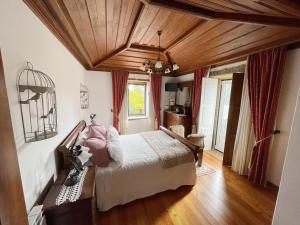 a bedroom with a bed and a wooden ceiling at Casa da Encruzilhada in Ponte de Lima