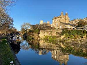 een groep boten geparkeerd op een rivier met een kasteel bij Grosvenor Apartments in Bath - Great for Families, Groups, Couples, 80 sq m, Parking in Bath