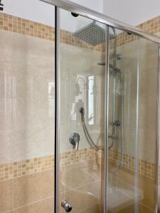 a shower with a glass door in a bathroom at Casa FERRARA in Taormina