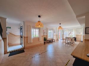 a living room with two pendant lights and a dining room at Victoria Hotel in Matalascañas