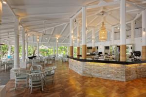 a restaurant with a bar and tables and chairs at Embudu Village Resort in South Male Atoll