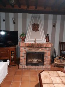 a living room with a fireplace and a tv at Casa de Aldea Florentina in Arenas de Cabrales