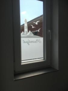 Una ventana en una habitación con un cartel. en Ferienwohnanlage Sturmhöhe en Welt