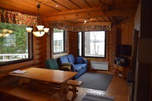 a living room with a blue couch and a table at Kaijansaaren Lomamökit in Tölvä