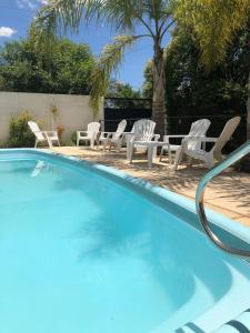 una piscina con sillas, una mesa y una palmera en Sueno Verde Colón en Colón