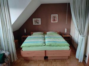 a bed in a room with two tables and two windows at Ferienwohnung Rhede in Rhede