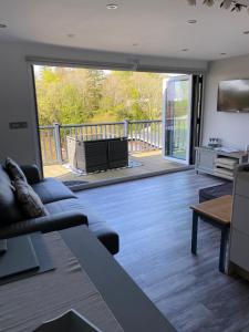 a living room with a couch and a view of a deck at SNOWDON LODGE Luxury Lodge Glan Gwna Holiday Park Caeathro Caernarfon Near Snowdonia in Caernarfon