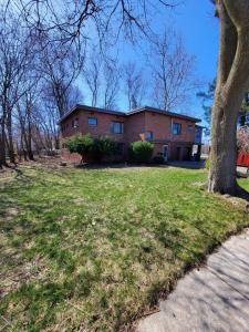 a brick house with a tree in front of it at The Gorge View Villa- With Private Yard & Free Parking-see full listing info in Niagara Falls