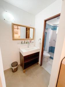 a bathroom with a sink and a toilet and a mirror at Hotel Cocoplum Beach in San Andrés
