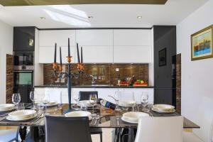 a dining room with a table with chairs and a kitchen at Villa AnBer in KoruÅ¡ce