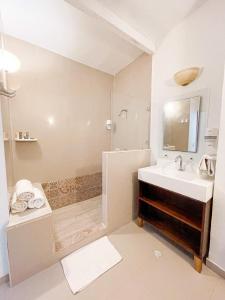 a white bathroom with a sink and a shower at Hotel Cocoplum Beach in San Andrés