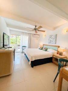 a bedroom with a bed and a desk and a television at Hotel Cocoplum Beach in San Andrés