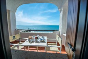 a table with food on a balcony with the ocean at Hotel Oasi Di Kufra in Sabaudia