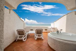 a bathroom with a tub and chairs and the beach at Hotel Oasi Di Kufra in Sabaudia