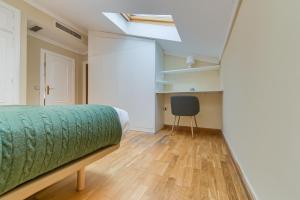 a bedroom with a bed and a chair in it at Holidays2Malaga Soho Penthouse in Málaga