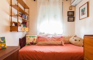 ein Schlafzimmer mit einem Bett mit Kissen und einem Fenster in der Unterkunft Habitación piso compartido in Sevilla