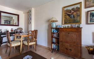 ein Esszimmer mit einem Tisch und einer Holzkommode in der Unterkunft Habitación piso compartido in Sevilla