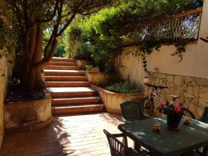 a patio with a table and a tree and stairs at Villa Ania in Mondello