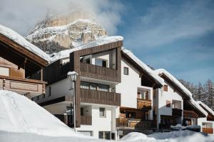 een gebouw met een met sneeuw bedekte berg op de achtergrond bij Appartamenti Ciasa Hanny in Colfosco