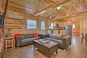 a living room with a leather couch in a cabin at Cozy Bidwell Cabin with Deck Trail and Creek Access! 