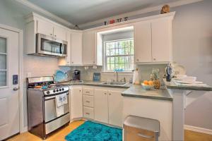 a kitchen with white cabinets and a blue rug at Pet-Friendly Lakefront Getaway with Hot Tub! in Coffee City