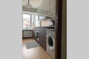 a kitchen with a washer and dryer in a room at Skolas street seaside space! in Jūrmala